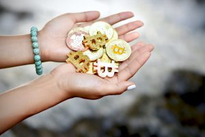 Two hands holding physical coins representing cryptocurrency