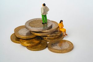 Stack of money with two people facing away from each other, as if not discussing finances