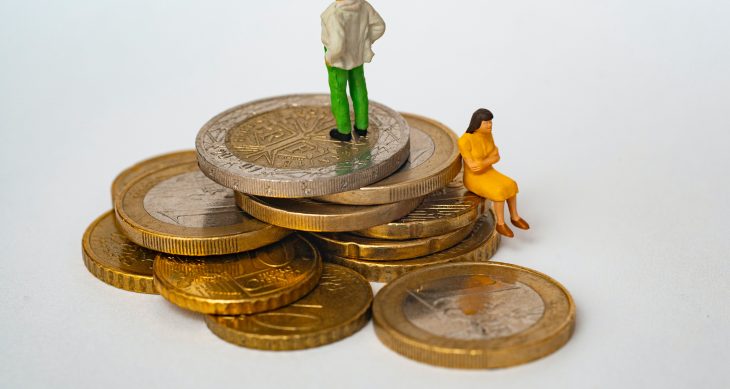 Stack of money with two people facing away from each other, as if not discussing finances